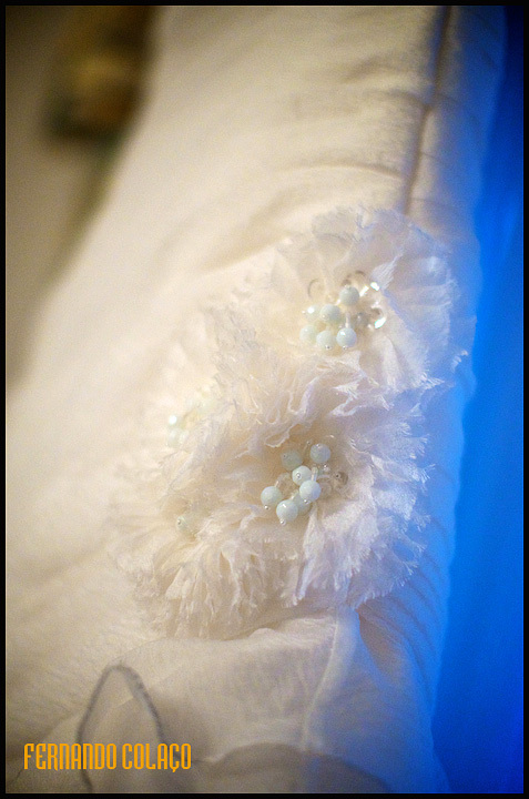 Detalhe de duas flores no vestido da noiva.