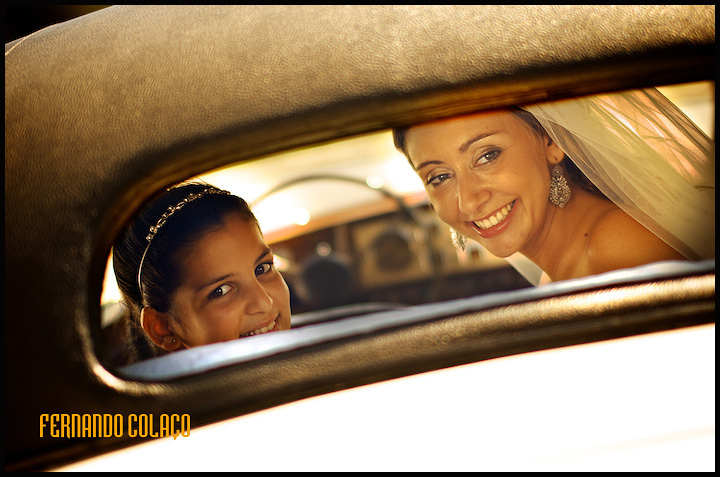 Pela janela de trás do automóvel, a noiva e a irmã a caminho da igreja.