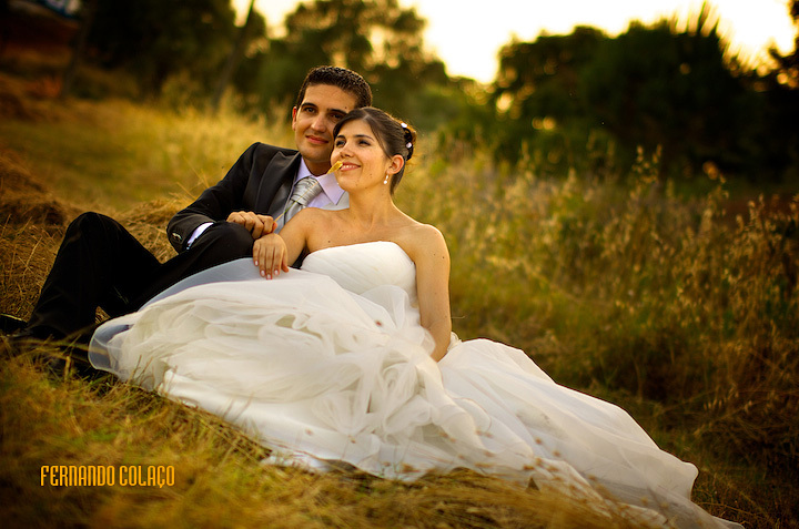 Sitting on the floor, the bride and groom in a golden light sunset.