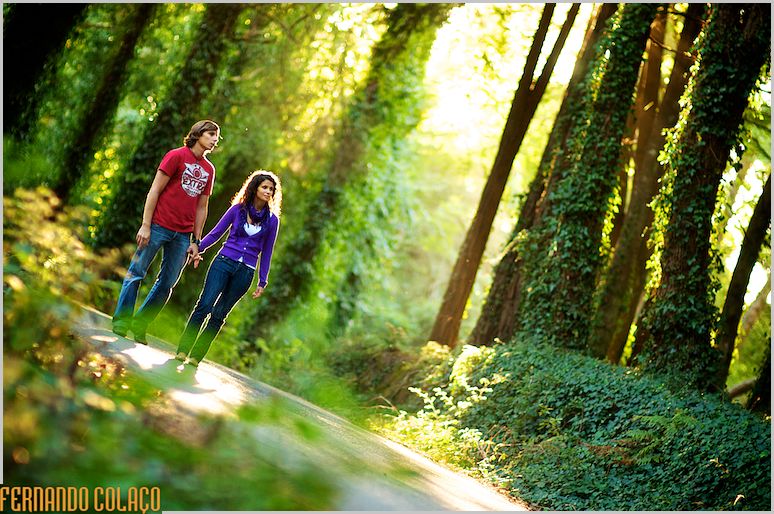 O casal na sessão de pré-casamento caminha numa estrada da Serra de Sintra.