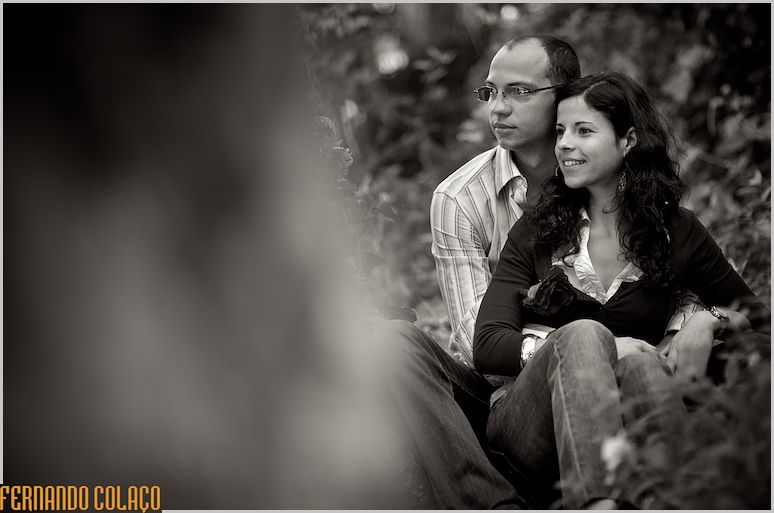 Na sessão de pré-casamento, os noivos sentados num bosque em Sintra.