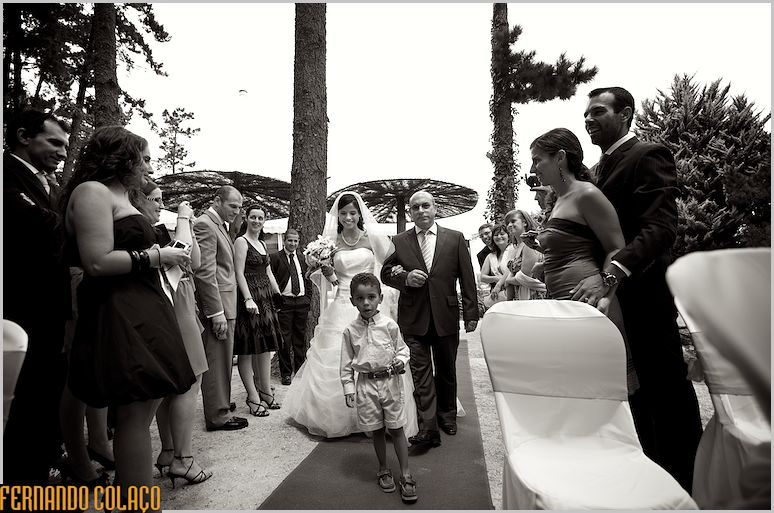 A noiva e o pai chegam ao local da cerimónia do casamento entre convidados.