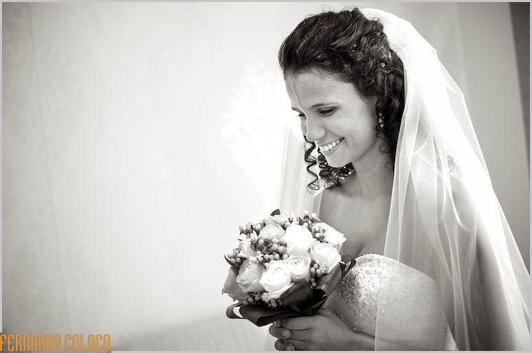 The bride smiles with the bouquet in her hand.