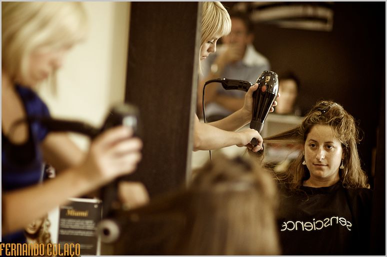 A noiva  num espelho do cabeleireiro a ser penteada.