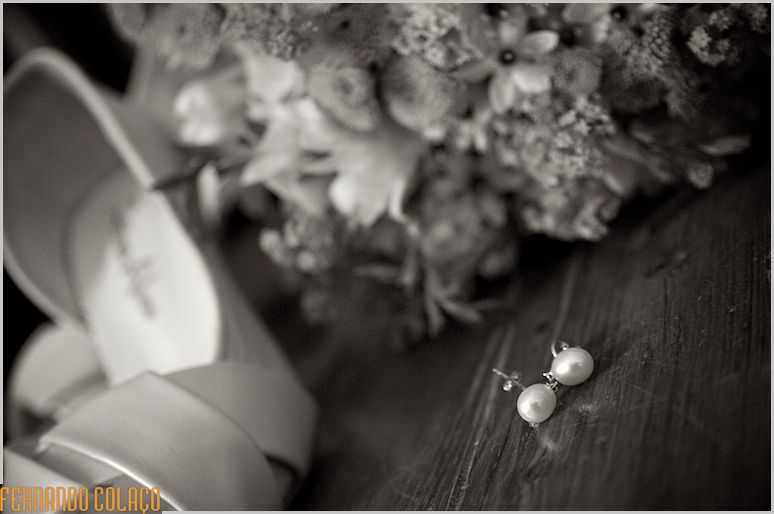 Os brincos da noivo junto do bouquet.