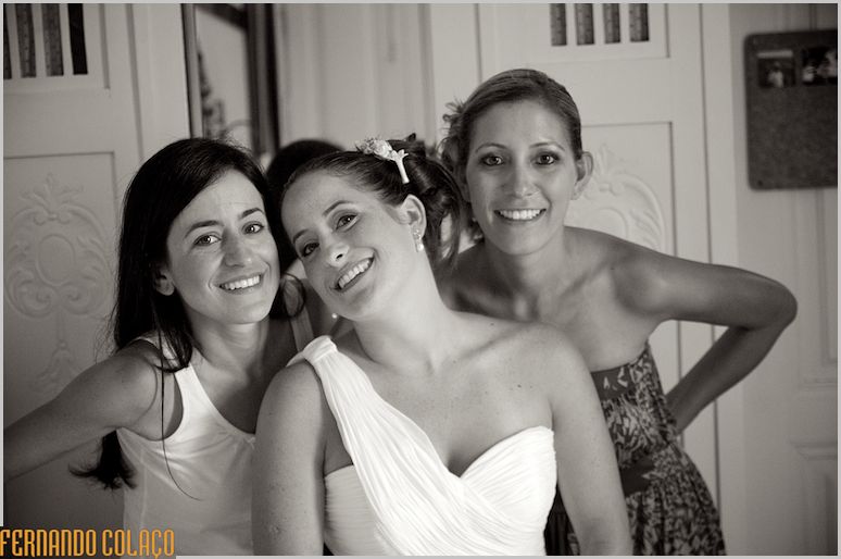 A noiva com duas amigas em pose para o fotógrafo de casamento.