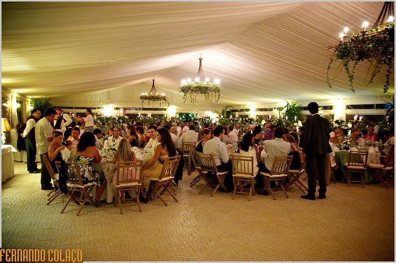 A sala da refeição com todos os convidados sentados à mesa, no Monte dos Agostos.