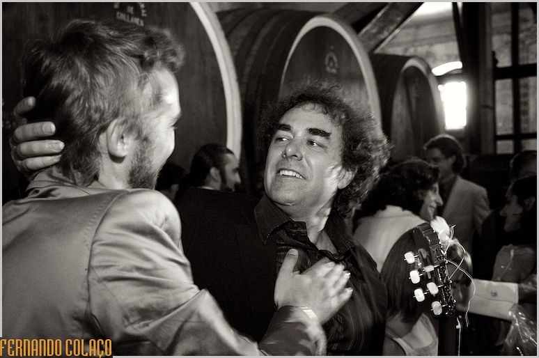 The musician at the ceremony and a friend of the groom congratulating him.