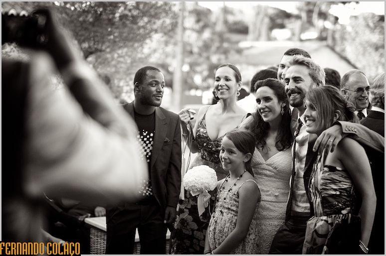 The newlywed couple within a group of friends in a photograph.