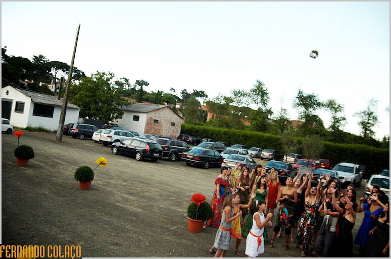 The bride's bouquet in the air, in the space of the wedding party, with the single women ready to catch it.