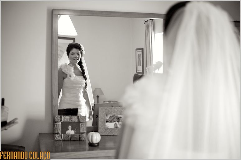 The bride looks at herself in the mirror to see if everything is ok before going to the wedding.