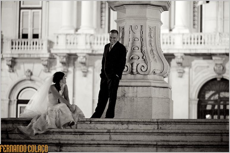 The bride and groom, in the post-wedding session, seated in front of the Lisbon City Hall.