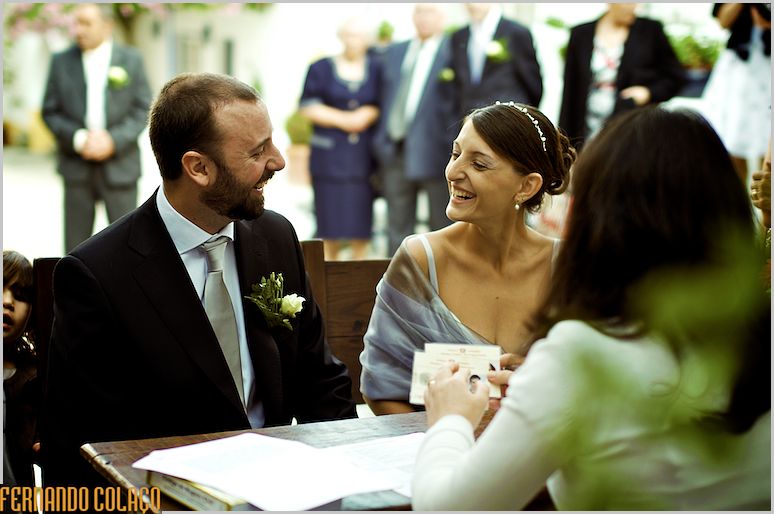The couple sitting, laughs at each other at the wedding ceremony table.
