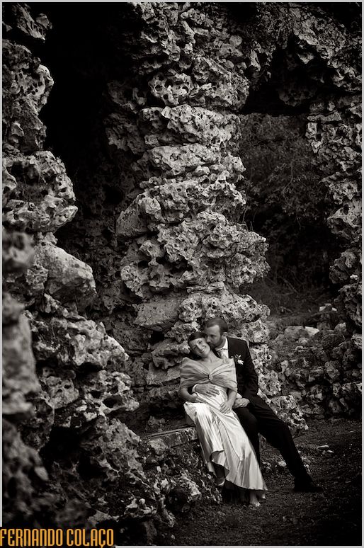 Sitting among ruins, the bride leaning against the groom.