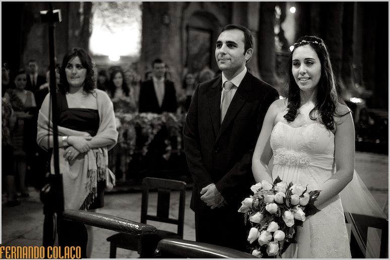 O casal, em pé, no altar da igreja de S. Domingos em Lisboa, tendo a noiva o bouquet na mão.