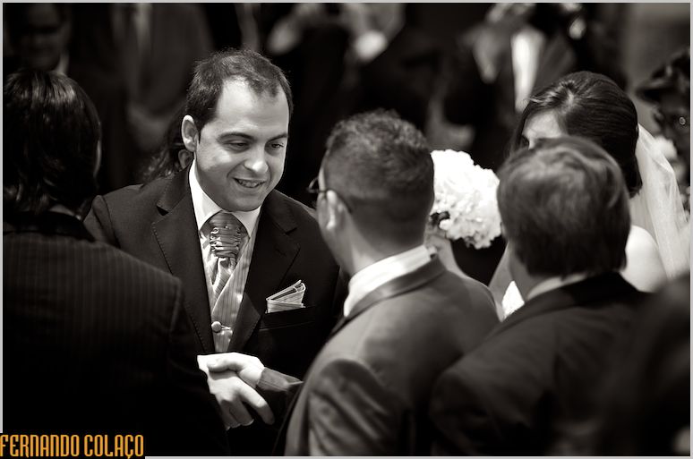 The groom receiving greetings from a wedding guest.
