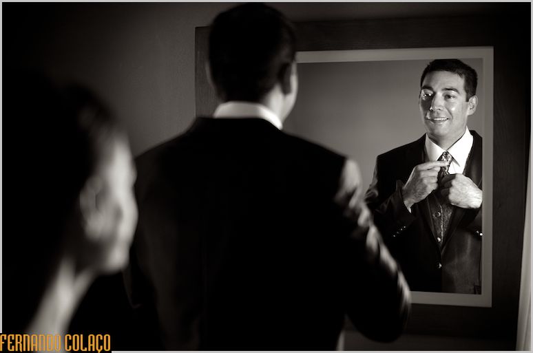 The groom's sister and he, looking at themselves in the mirror at the end of dressing for the wedding ceremony.