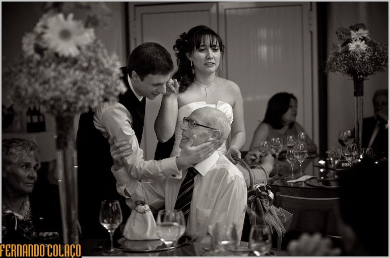 At the wedding party, the groom caresses a guest, close to the bride.