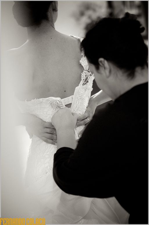 Buttoning up the bride's dress.