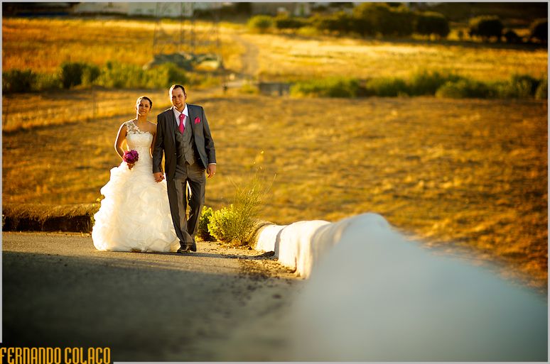 Walking up the street with fields golden by the late afternoon sun, the bride and groom return to Quinta do Palhas.