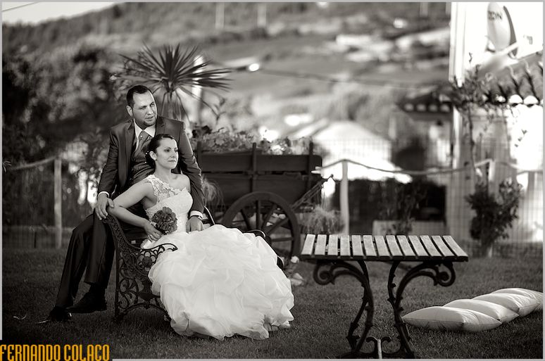 The couple sitting on a bench in the garden of Quinta do Palhas, in the middle of decorative.
