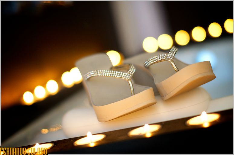 The bride's shoes between lit candles.