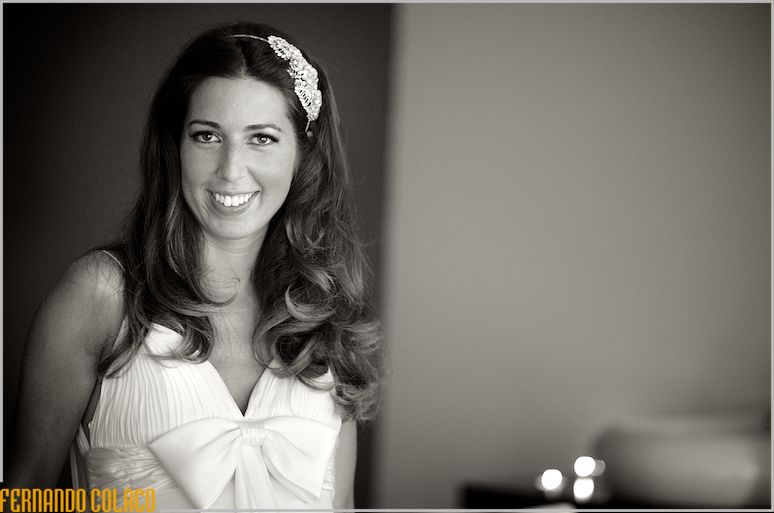 The bride looks at the wedding photographer in black and white portrait.