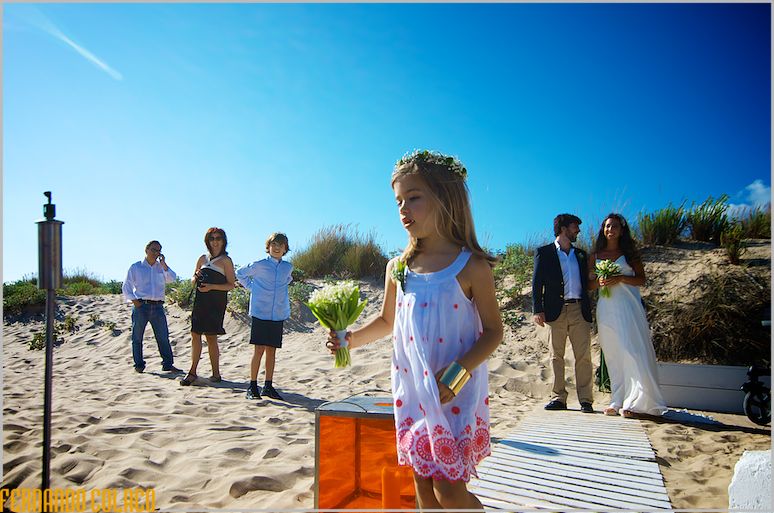 Girl with flowers in her hand in front of the bride and her brother at the wedding ceremony site.