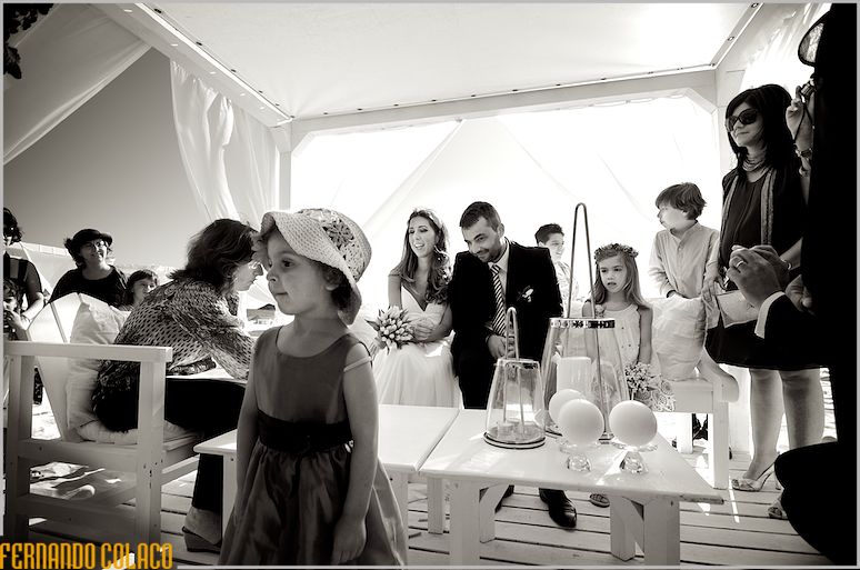 Bride and groom seated at the ceremonial table, next to godparents and guests.