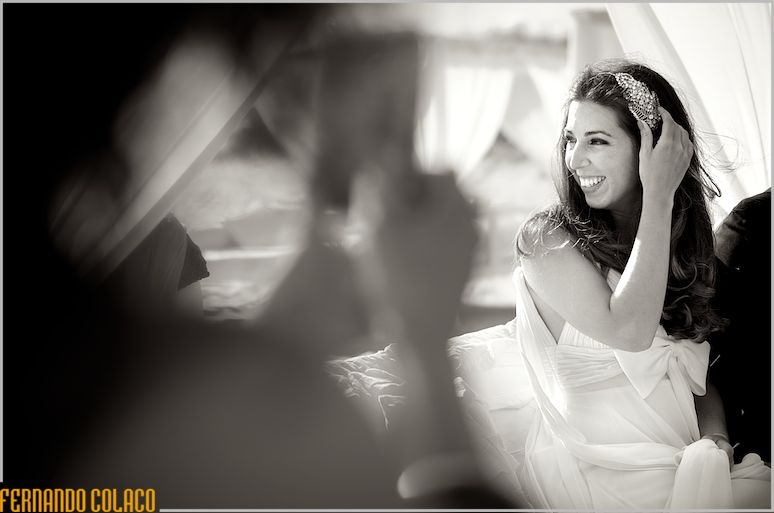 The bride, with her hand in her hair and laughing, during the wedding ceremony.