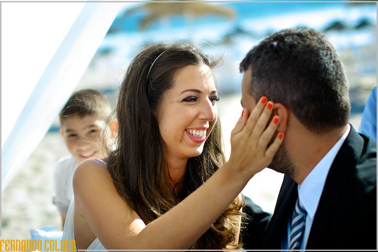The bride caresses the groom's face.