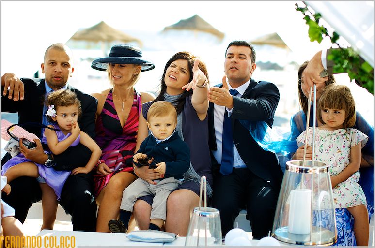 he bride and groom's friends, with their children in their arms, play with them.