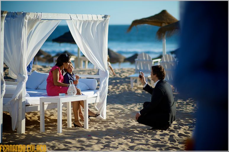 A wedding guest takes a picture of his wife and young daughter.