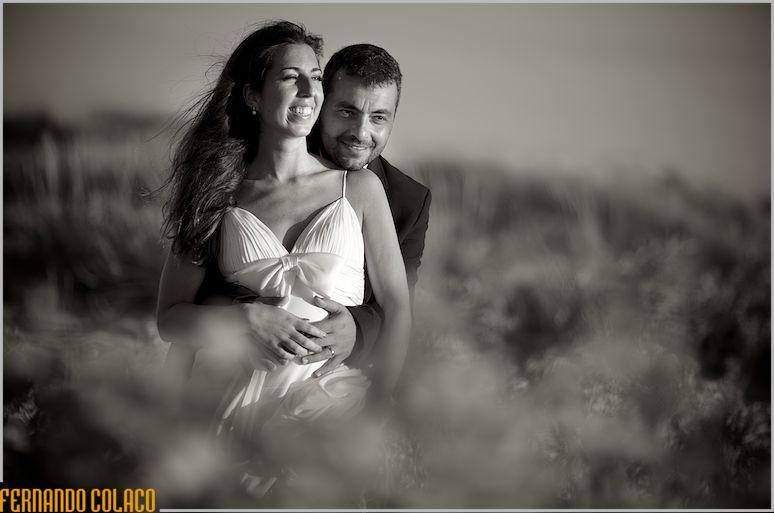 The newlywed couple, in the middle of the plants next to the Waikiki Bar im Praia da Sereia in Caparica, by the wedding photographer.