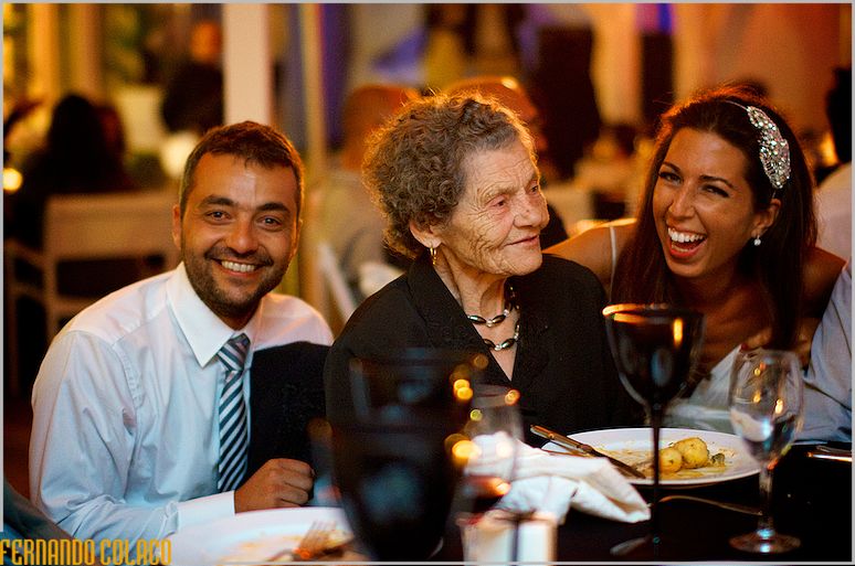The bride and groom together with the groom's grandmother at the wedding meal table.