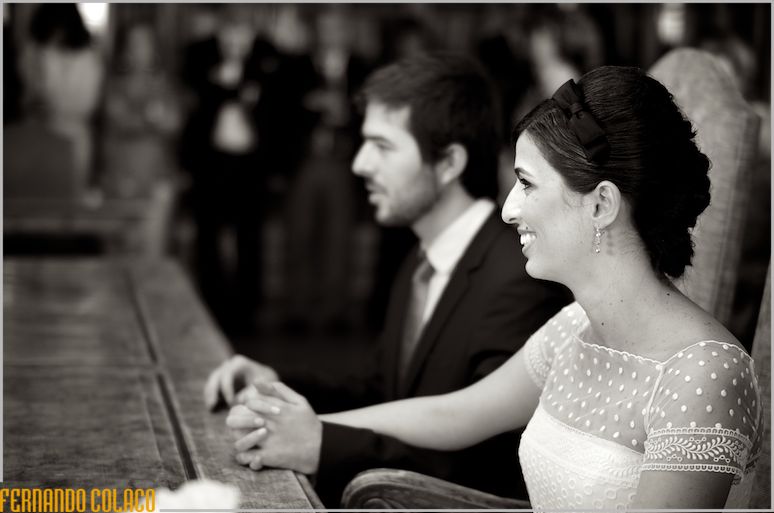 The bride with the groom and holding hands while the wedding ceremony takes place.