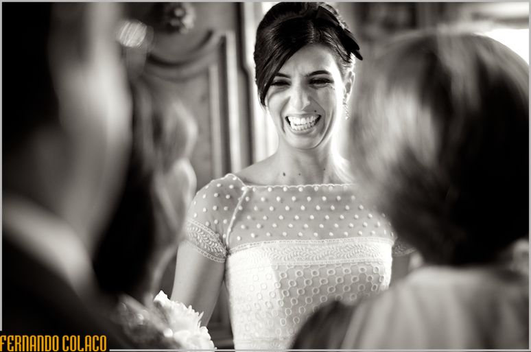 After the wedding ceremony, the bride laughs at guests, who greet her.