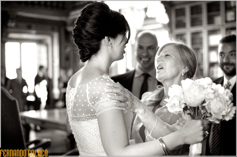 Bride, with bouquet in hand, receives congratulations from a guest.