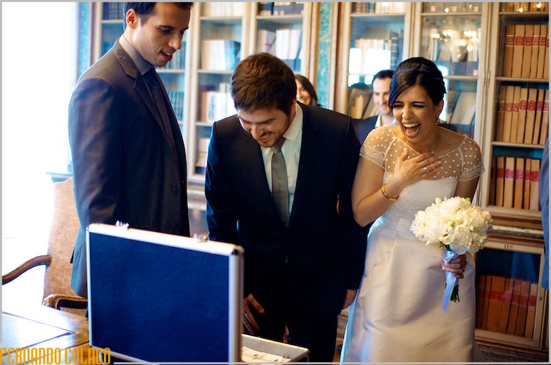 The couple laughing a lot when looking at a suitcase with gifts.