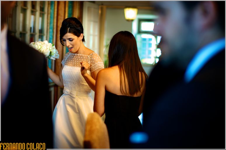 The bride, bouquet in hand, celebrates with a guest.