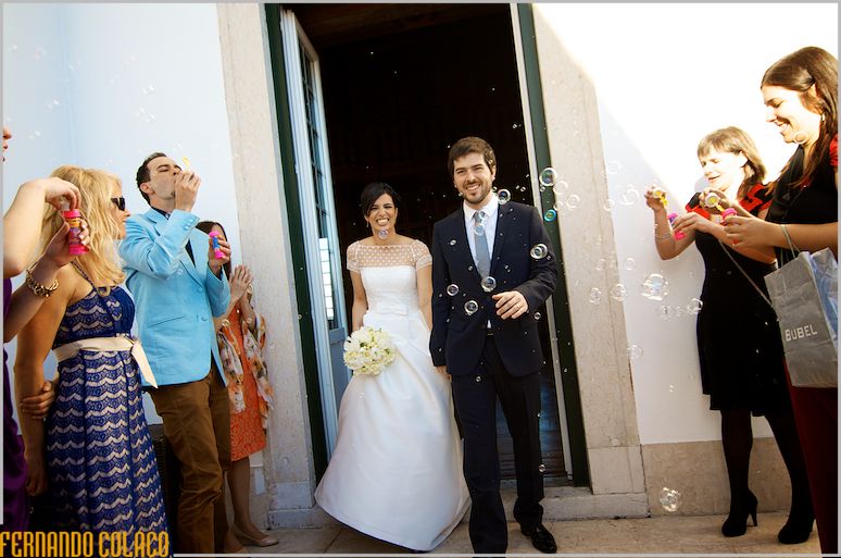Leaving the ceremony room, the bride and groom between soap bubbles.