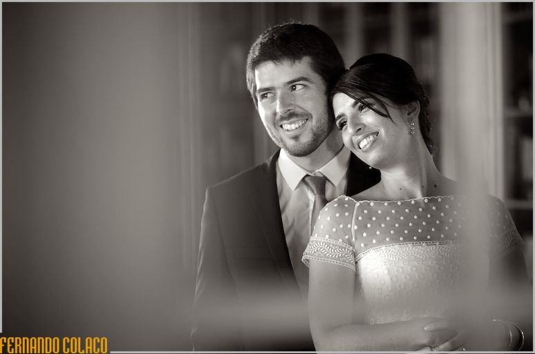 In a portrait seen through a window, the bride and groom in the library of the Palácio da Cruz Vermelha.