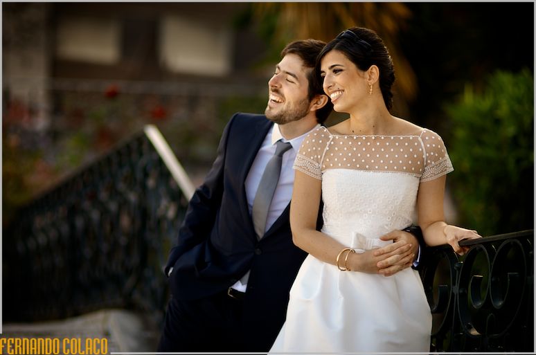 On a balustrade on the staircase, the bride and groom look out over the Tagus River.