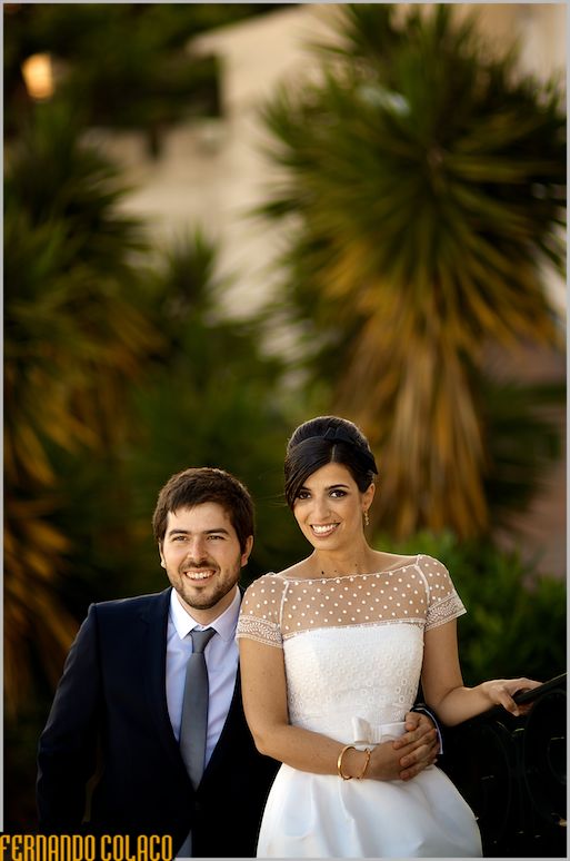The newlywed couple in front of tropical plants.