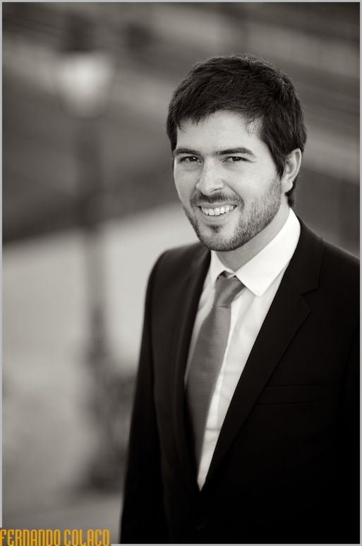 The groom in a black and white portrait with the sun set.