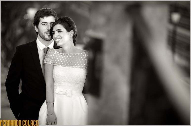 Leaning against the groom, who talks to her at the wedding photography session.