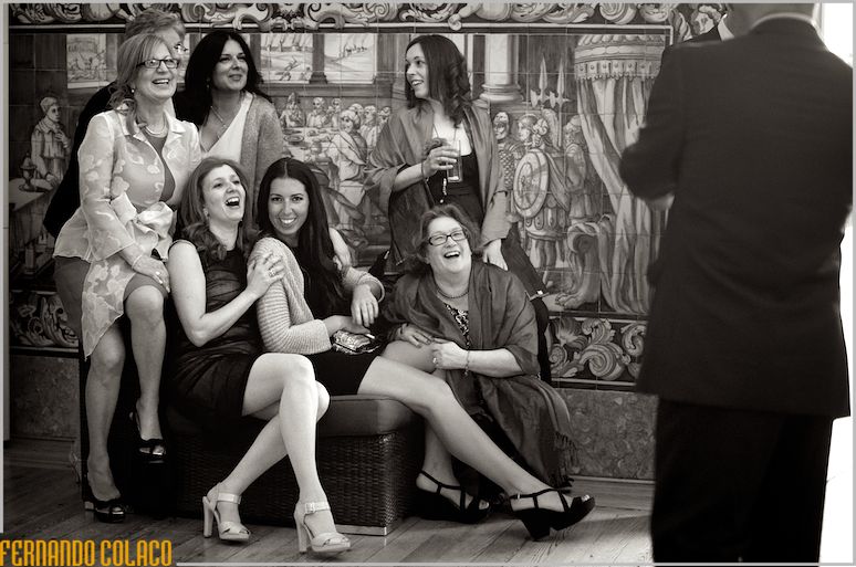 A group of some wedding guests pose for someone, who takes a picture of them.