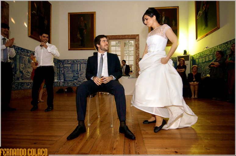 Groom, seated, while the bride dances around him, in a game of the wedding party.