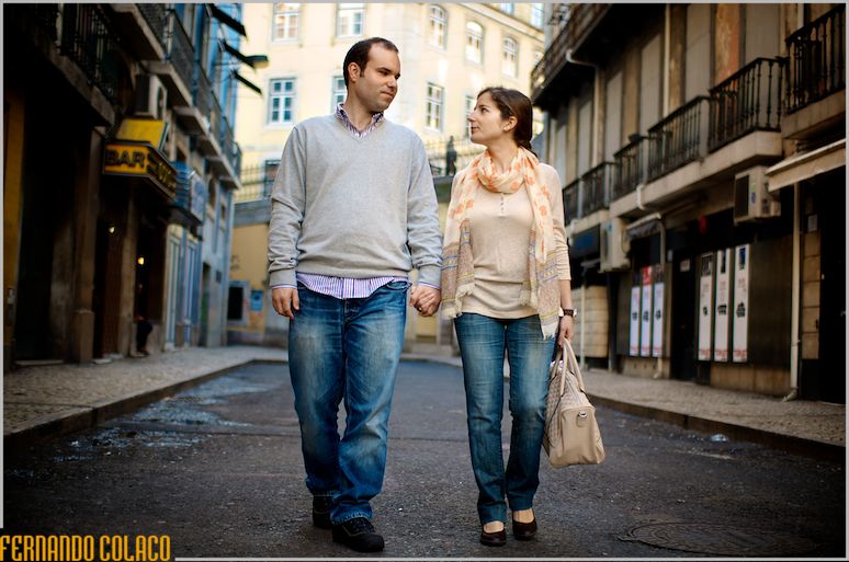 The couple, in the pre-wedding session, walks in a street in downtown Lisbon.