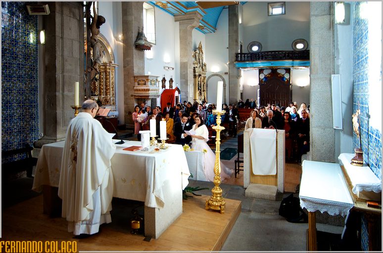 View of the Igreja Matriz do Fundão from the altar, with the priest, the bride and groom and the wedding guests.